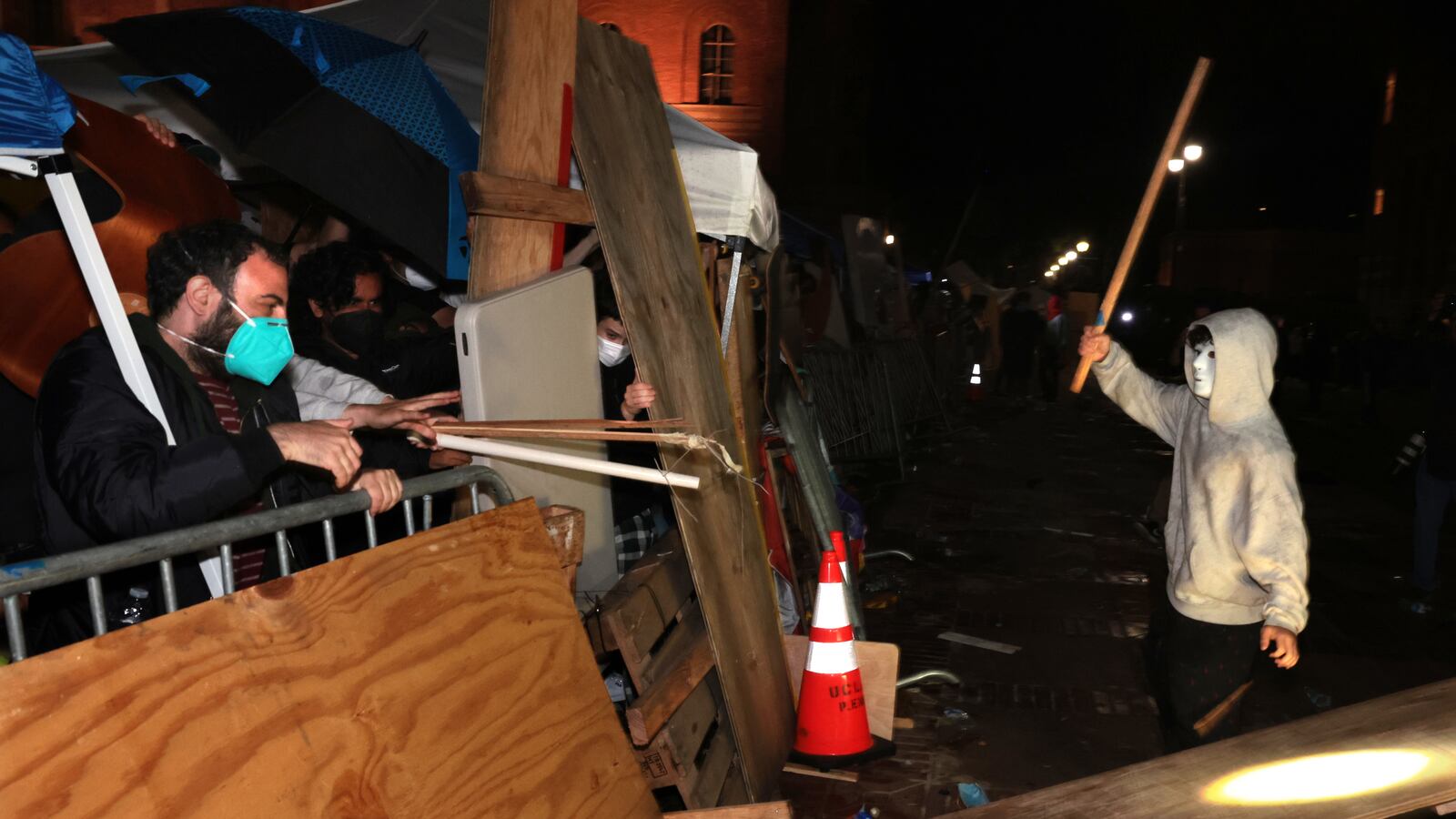 Pro-Palestinian protestors defend themselves against a pro-Israeli supporter at an encampment at UCLA early Wednesday morning.
