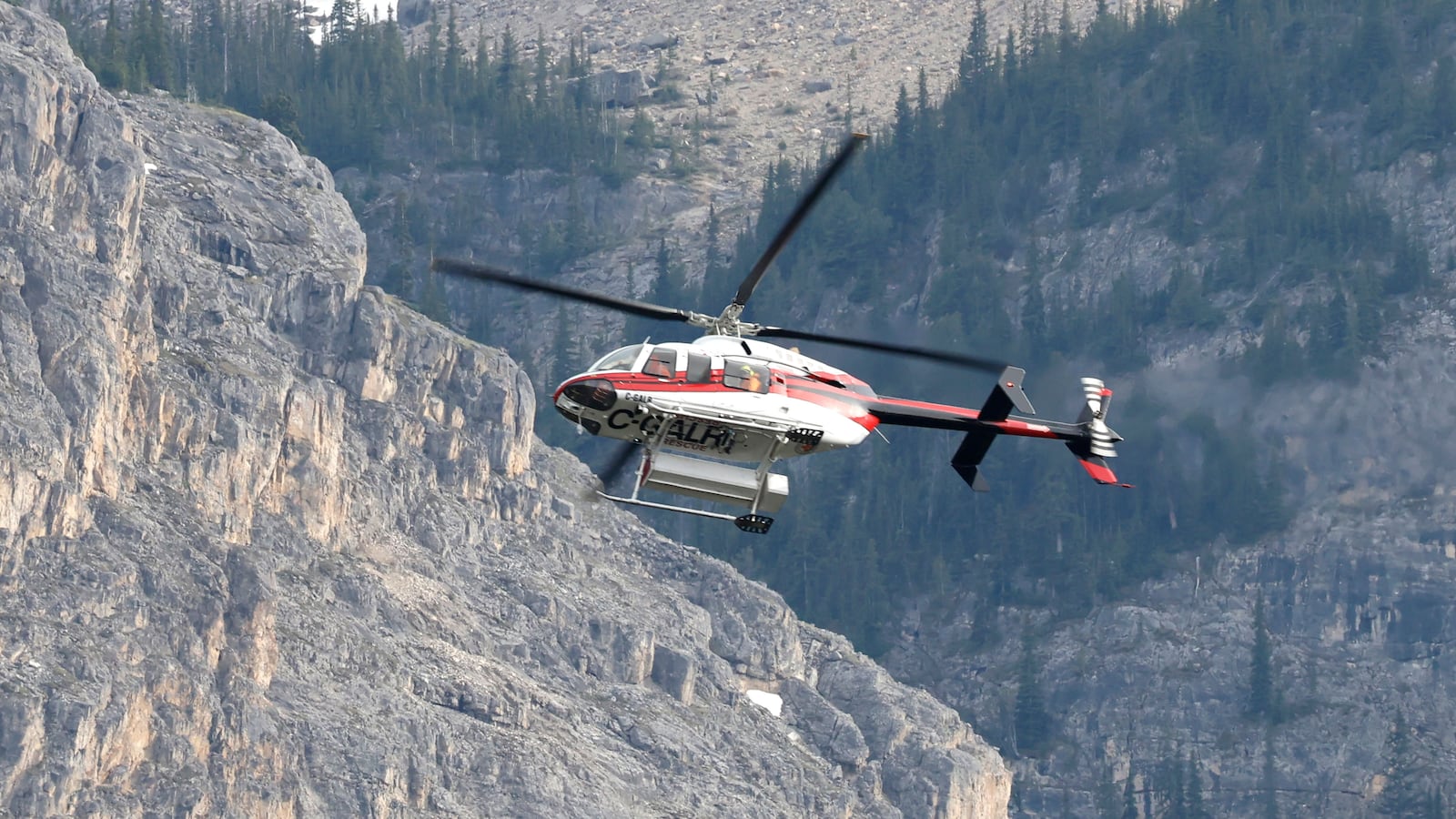 A helicopter is seen close to the scene of a rock slide near Bow Glacier Falls, north of Lake Louise, Alta. in Banff National Park on Thursday, June 19, 2025.