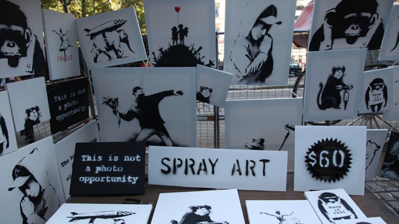 articles/2013/10/14/banksy-s-biggest-trick-yet-selling-his-art-on-the-street-for-60/131014-banksy-stall-wilkinson-tease_oyp7c7