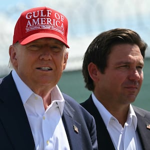 (L/R) US President President Donald Trump and Florida Governor Ron DeSantis tour a migrant detention center, dubbed "Alligator Alcatraz," located at the site of the Dade-Collier Training and Transition Airport in Ochopee, Florida on July 1, 2025. President Trump is visiting a migrant detention center in a reptile-infested Florida swamp dubbed "Alligator Alcatraz." Trump will attend the opening of the 5,000-bed facility -- located at an abandoned airfield in the Everglades wetlands -- part of his expansion of deportations of undocumented migrants, his spokeswoman said. (Photo by ANDREW CABALLERO-REYNOLDS / AFP) (Photo by ANDREW CABALLERO-REYNOLDS/AFP via Getty Images)