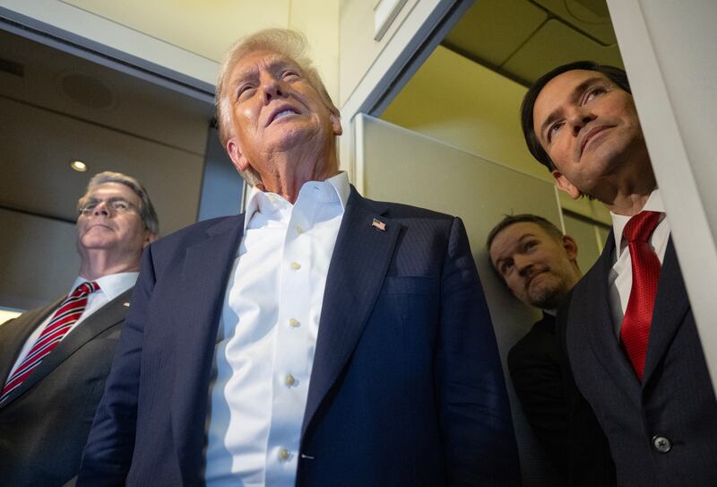 US President Donald Trump speaks as US Treasury Secretary Scott Bessent (L), US Secretary of State Marco Rubio (R), and US Trade Representative Jamieson Greer look on as they talk to the media aboard Air Force One as he flies to Japan on October 27, 2025. Donald Trump headed to Japan on October 27, the next leg of an Asia tour that could see the US president and China's Xi Jinping