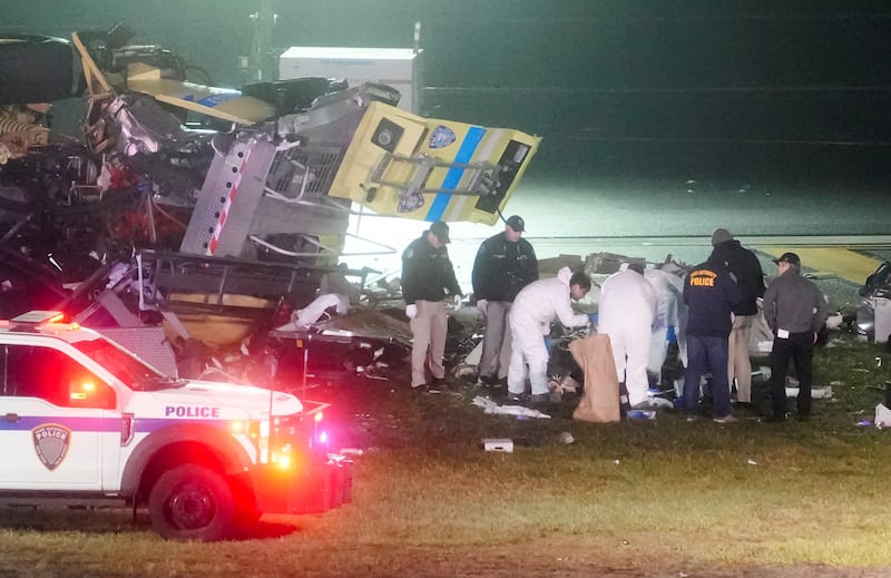 Investigators inspect the wreckage of a fire truck after it collided with an Air Canada Express jet that was landing at LaGuardia Airport in Queens, New York, U.S. March 23, 2026.
