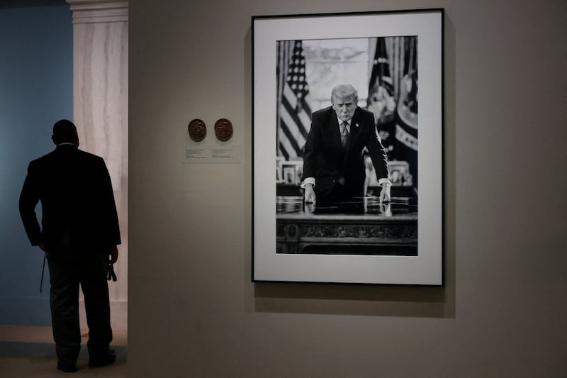 People view the portrait of U.S. President Donald Trump, taken by official White House photographer Daniel Torok which is the basis of a proposed U.S. Mint semiquincentennial commemorative gold coin design, on display at the Smithsonian National Portrait Gallery in Washington, D.C., U.S., March 19, 2026.