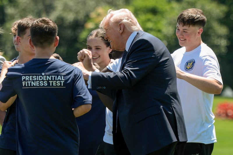 WASHINGTON, DC - MAY 05: U.S. President Donald Trump joins young athletes exercising following a proclamation signing in the Oval Office of the White House on May 05, 2026 in Washington, DC. President Trump signed a presidential memorandum restoring the Presidential Fitness Test Award, which was reinstated by executive order in July 2025 and reintroduces a performance-based benchmark in physical education. (Photo by Anna Moneymaker/Getty Images)