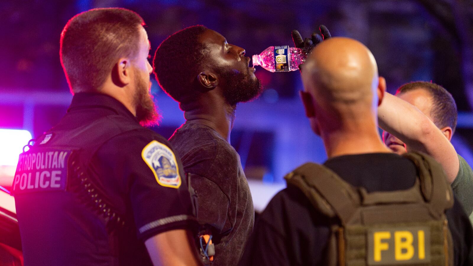 WASHINGTON, DC - AUGUST 17: Members of the Federal Bureau of Investigation (FBI), Homeland Security Investigations (HSI), the Secret Service, and Metropolitan Police Department (MPD) give an individual they detained water on 7th Street NW on August 17, 2025 in Washington, DC. U.S. President Donald Trump deployed federal officers and the National Guard to the District in order to place the DC Metropolitan Police Department under federal control and assist in crime prevention in the nation's capital. (Photo by Kayla Bartkowski/Getty Images)