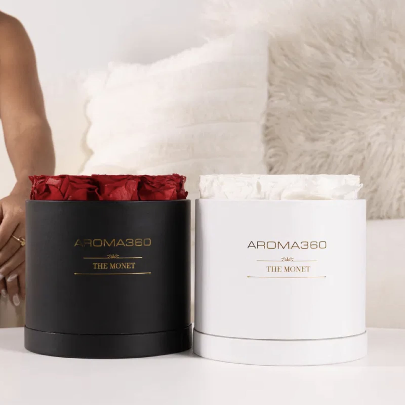 Aroma360 Monet Scent Diffusers displayed in black and white bases with preserved red and white roses, styled in a modern living room as an elegant Valentine’s Day gift and decorative home fragrance diffuser.