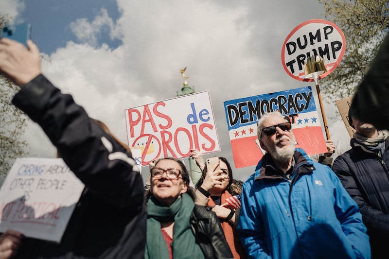 People are listening to a speech and a sign that reads Pas de rois during a protest against the far right as part of the day of protest No Kings at Place de la Bastille in Paris France on March 28, 2026. (Photo by Bastien Ohier / Hans Lucas / AFP via Getty Images)