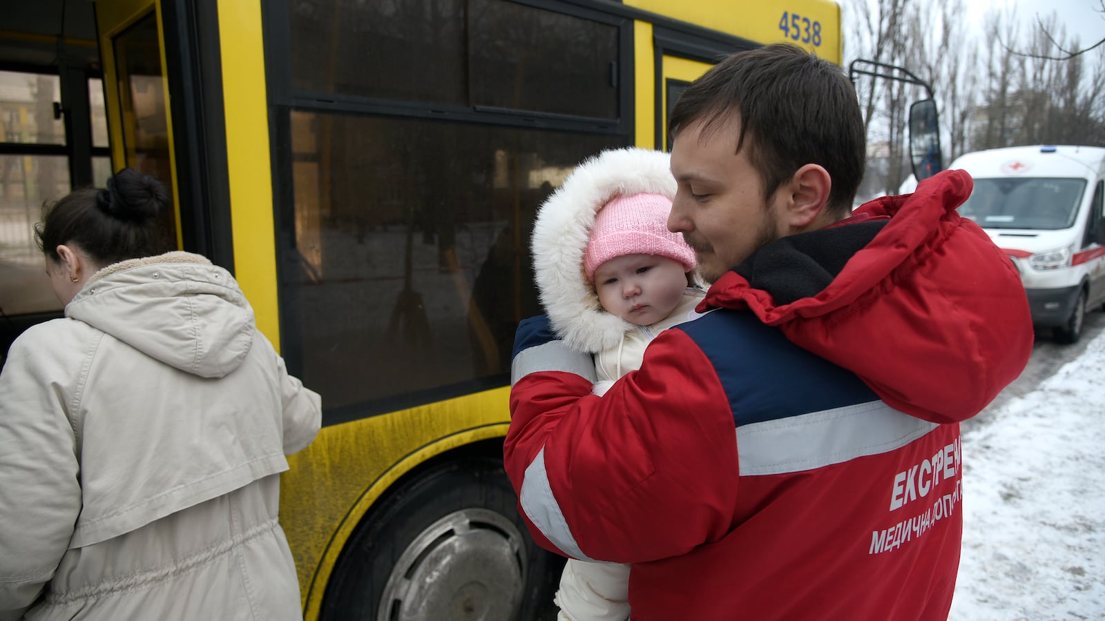 A paramedic holds a baby girl as people evacuated from a five-story residential building damaged by Russian missile