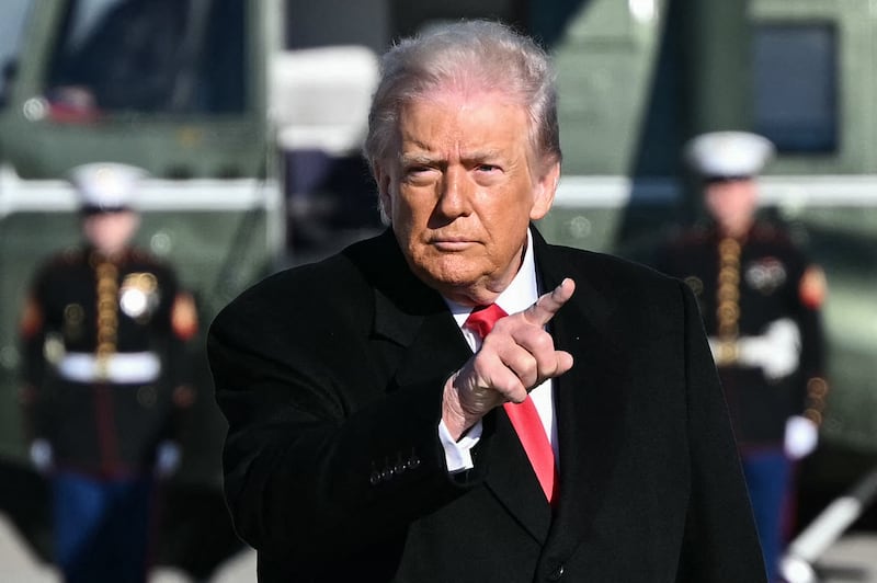 US President Donald Trump gestures as he walks to board Air Force One at Joint Base Andrews, Maryland on January 13, 2026.