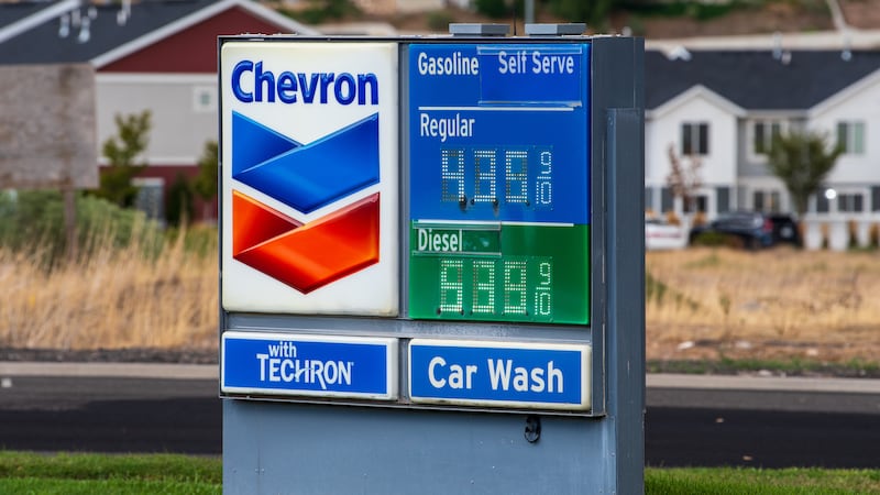 A close-up view shows a Chevron roadside fuel price sign standing near a roadway in Santaquin, Utah, United States, on August 30, 2026. The sign displays current retail pricing for self-serve regular gasoline at $4.35 and diesel at $5.39 per gallon against a background of residential housing.
