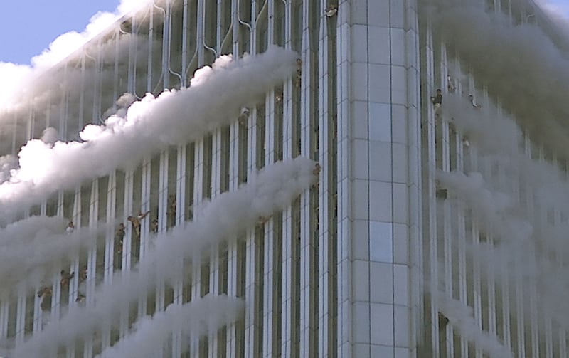 People hang from windows of the World Trade Center after two planes hit the building.