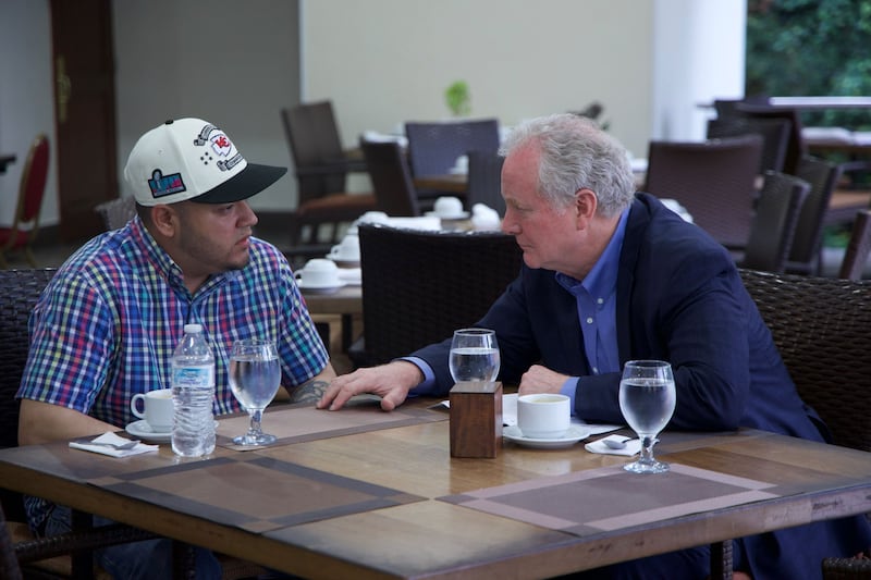 Kilmar Abrego Garcia and Senator Chris Van Hollen sit at a table in a restaurant.