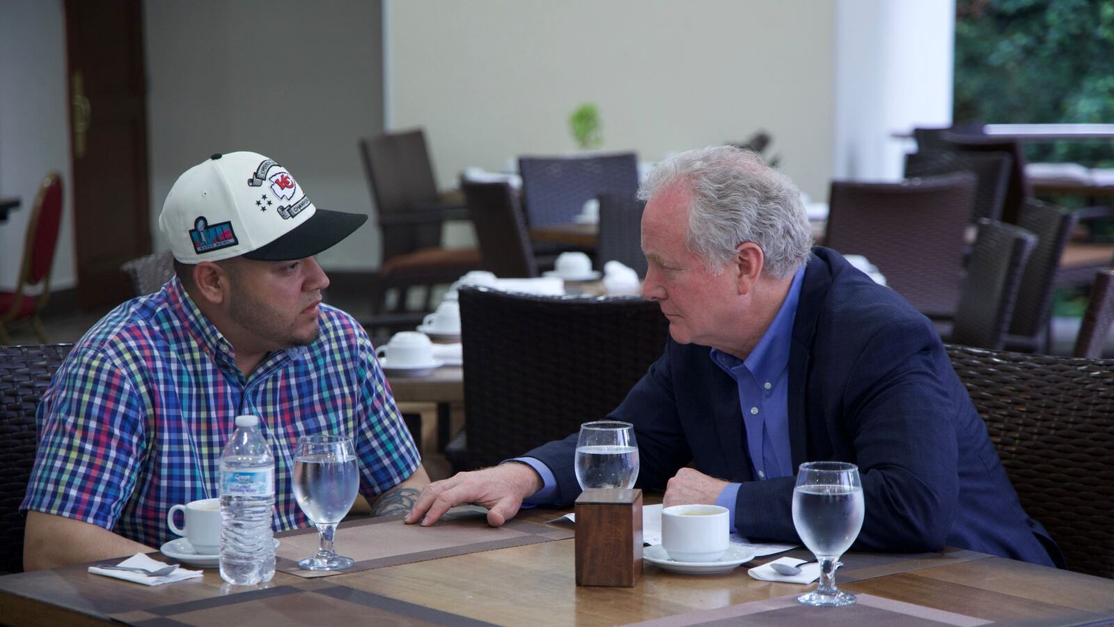 Kilmar Abrego Garcia and Senator Chris Van Hollen sit at a table in a restaurant.
