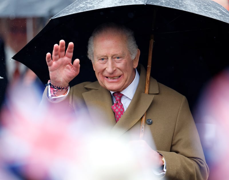 King Charles III shelters under an umbrella as he meets members of the public during a walkabout after visiting The Sun Inn on February 5, 2026 in Dedham, Essex.