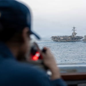 A U.S. Navy sailor looks out as Nimitz-class aircraft carrier USS Abraham Lincoln