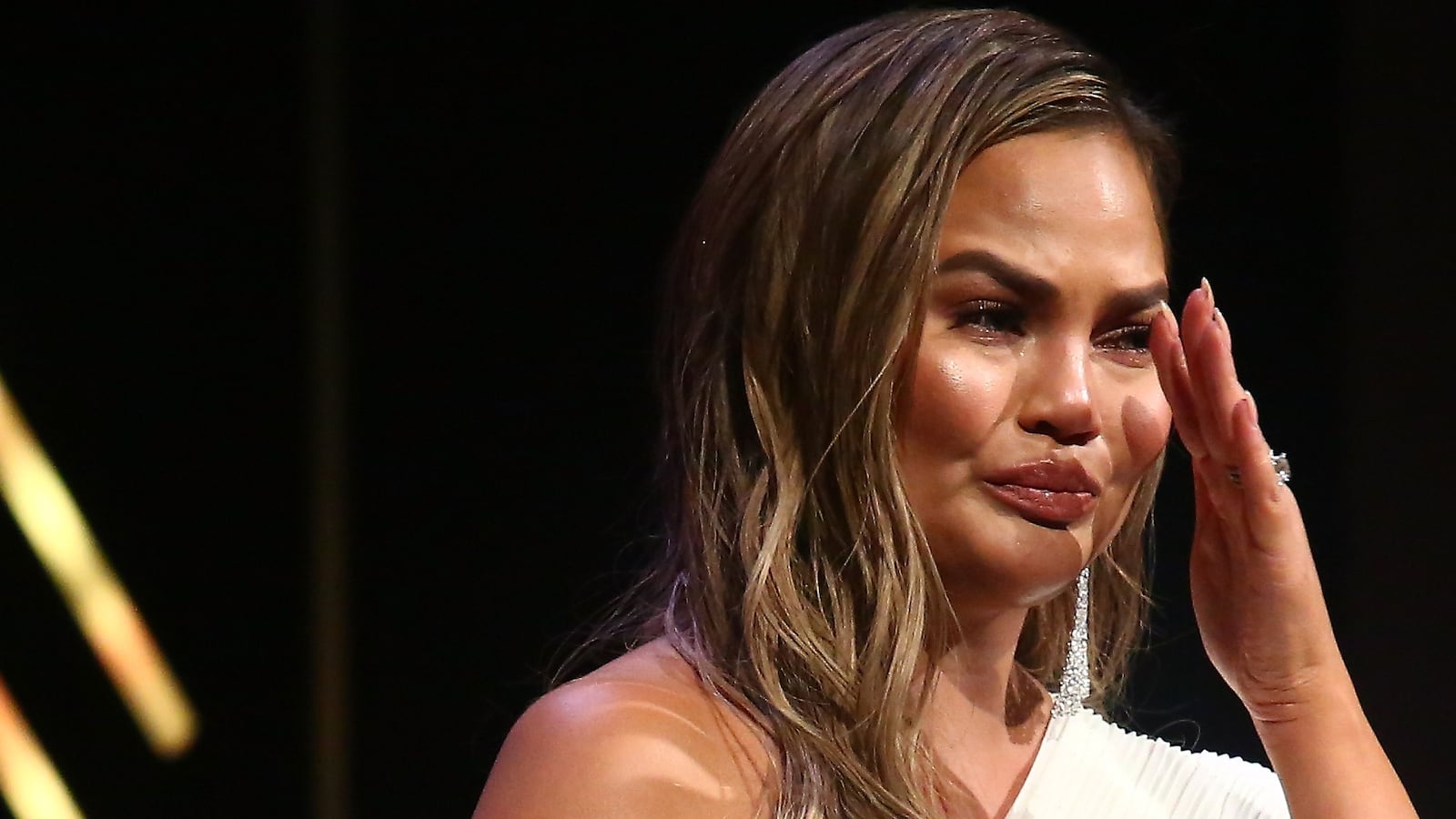 Chrissy Teigen crying on stage.