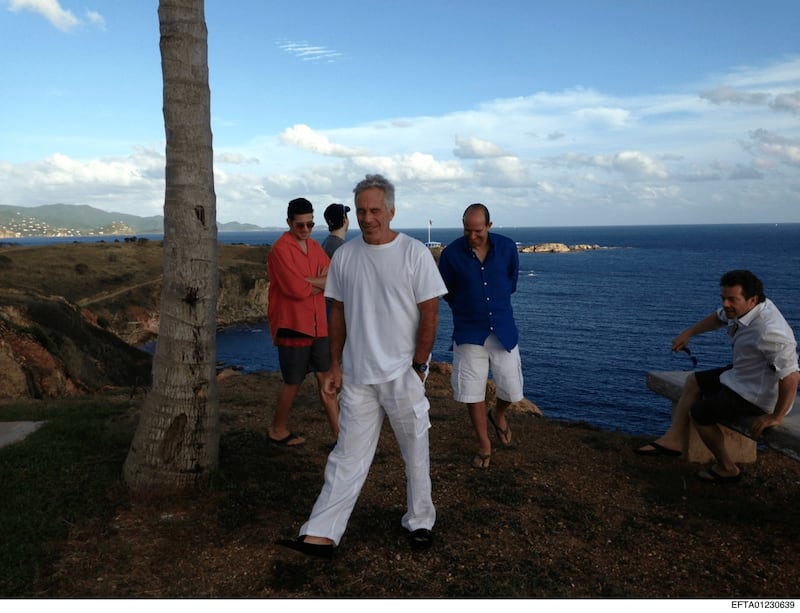 Jeffrey Epstein in white photographed on his island against the background of the sea with three other men