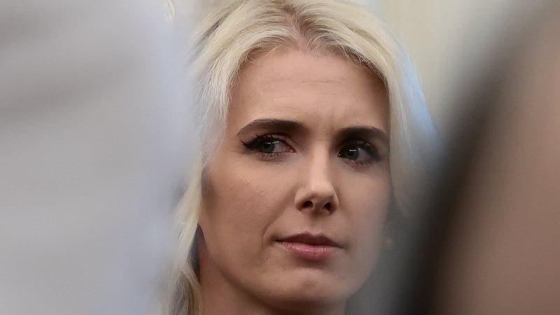 A concerned Natalie Harp looks on as Donald Trump talks about healthcare policies in the Oval Office.