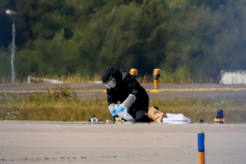FILE PHOTO: A police officer in protective clothing works at Leipzig/Halle Airport in Schkeuditz, Germany, August 5, 2026, after the police said explosives experts examined a drone near a runway, and after a DHL cargo aircraft hit an unknown object as it was climbing away from the airport overnight, prompting an unscheduled landing in Hanover, according to a source familiar with the incident. REUTERS/Axel Schmidt REFILE - QUALITY REPEAT/File Photo