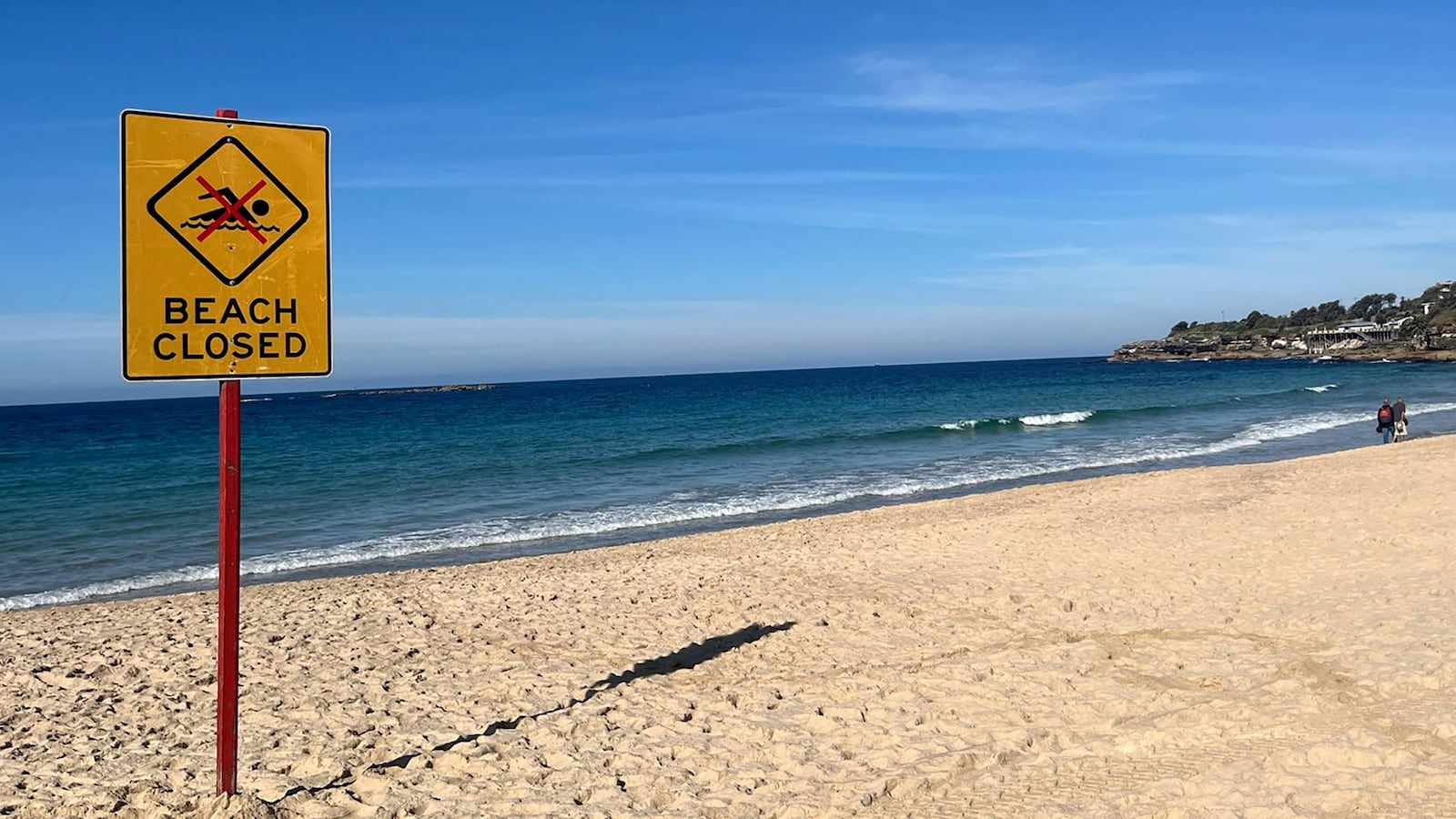 A beach closed sign is displayed at Coogee Beach in Sydney on June 13, 2026. Beachgoers dragged a badly injured swimmer from the water at Coogee, one of Australia's most beloved beaches and popular spot for tourists, after she was mauled by a shark on June 13, police said. Four people have been killed in an unusual spate of shark attacks around Australia this year.
