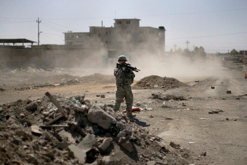 A U.S. soldier secures the road while Major-General Mark Hertling, the commander of the U.S. forces in northern Iraq, holds a joint battlefield circulation patrol in Mosul.