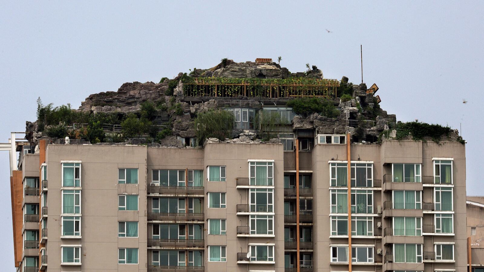 cheats/2013/08/17/hidden-villa-built-atop-skyscraper/130815-china-rock-garden-weird-cheat_jndpkh