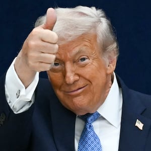 President Donald Trump gives a thumbs up as he departs the stage during the signing ceremony on December 4, 2025.