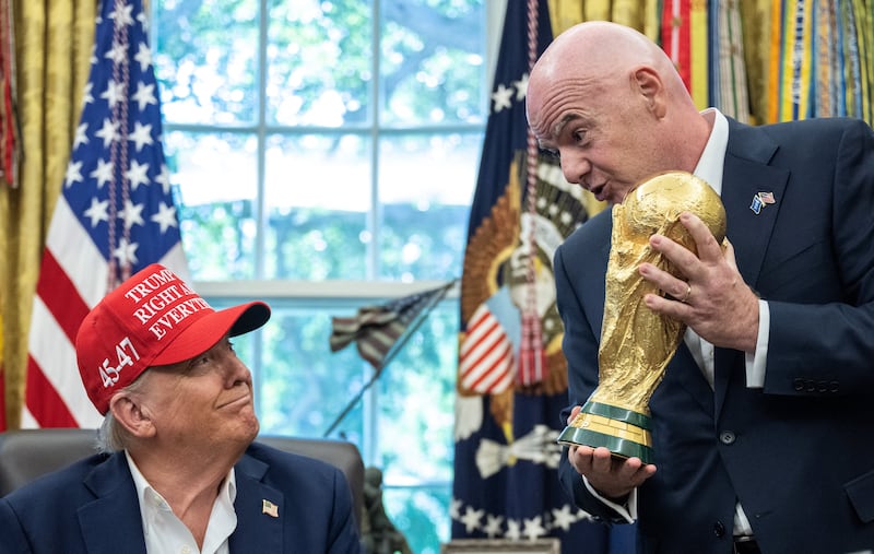 FIFA President Gianni Infantino hands the World Cup trophy to President Donald Trump in the Oval Office of the White House in Washington, DC, on August 22, 2025.