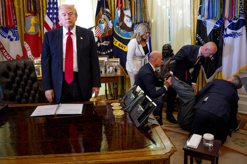 WASHINGTON, DC - NOVEMBER 06: (EDITOR'S NOTE: Alternate Crop) U.S. President Donald Trump stands by as attendees help a guest after he collapsed during during an event on lowering drug prices in the Oval Office at the White House on November 06, 2025 in Washington, DC. Trump announced that his administration has reached agreements with drugmakers Eli Lilly and Novo Nordisk that would lower the price of some GLP-1 weight loss medications. (Photo by Andrew Harnik/Getty Images)