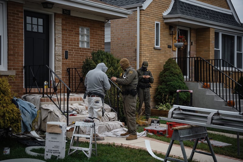 Federal agents, including Chief Patrol Agent Gregory Bovino of the El Centro Sector for U.S. Customs and Border Protection, detain two men working on a home in the Edison Park neighborhood