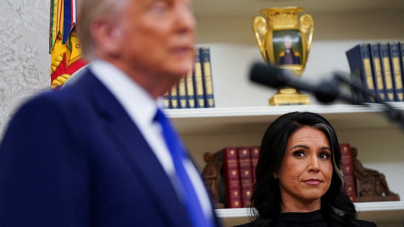 Incoming Director of National Intelligence Tulsi Gabbard looks at U.S. President Donald Trump during her swearing in ceremony as DNI in the Oval Office at the White House in Washington, D.C., U.S., February 12, 2025.