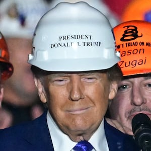 Members of "Steelworkers for Trump" pose with former US President and Republican presidential candidate Donald Trump after they gifted him a hard hat during a campaign rally at Arnold Palmer Regional Airport in Latrobe, Pennsylvania, October 19, 2024. (Photo by Jim WATSON / AFP) (Photo by JIM WATSON/AFP via Getty Images)