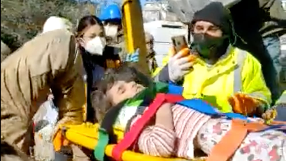 Rescue workers carry a 4-year-old girl away from rubble