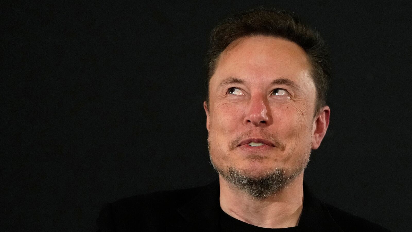 Elon Musk gestures to British Prime Minister Rishi Sunak at a summit.