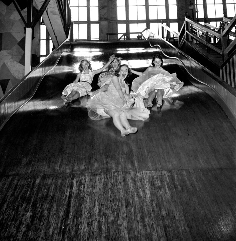 Models from the CBS gameshow, "The Big Payoff," Connie Mavis, Cindy Robbins, Pat Conway, and Marion James ride on the giant slide inside the "pavilion of Fun" at Steeplechase Park on May 11, 1953, Coney Island, Brooklyn, NY.