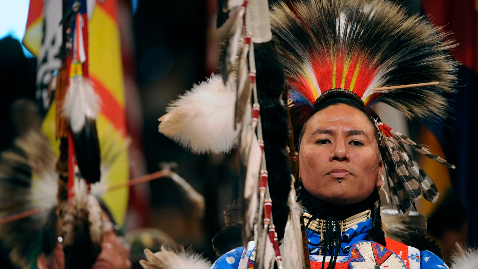 Nathan Chasing Horse of Rosebud, South Dakota, and a member of the Sioux Tribe, leads the Color guard at the beginning of the grand entry into the coliseum.