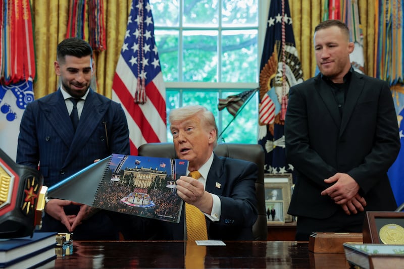 President Donald Trump shows an image of the White House with the Octagon to illustrate the concept of the Ultimate Fighting Championship planned for June 14, 2026, as he holds an event with UFC fighters Justin Gaethje and Ilia Topuria in the Oval Office at the White House in Washington, D.C., U.S., May 6, 2026.