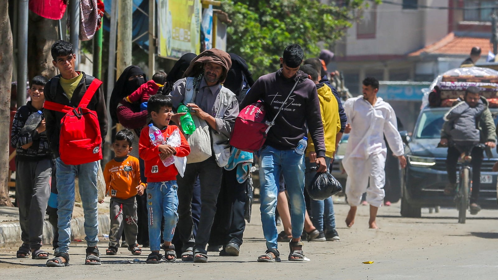 Gazans evacuate Rafah, carrying their belongings with their heads hung.