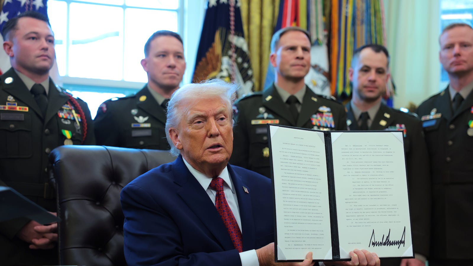 WASHINGTON, DC - DECEMBER 15: U.S. President Donald Trump poses with a recently signed executive order classifying fentanyl as a "weapon of mass destruction," during a ceremony for the presentation of the Mexican Border Defense Medal in the Oval Office of the White House on December 15, 2025 in Washington, DC. During the ceremony, Trump recognized the first 13 service members to receive the recently established Mexican Border Defense Medal (MBDM), which recognizes service members supporting Customs and Border Protection on the U.S.-Mexico border. (Photo by Anna Moneymaker/Getty Images)