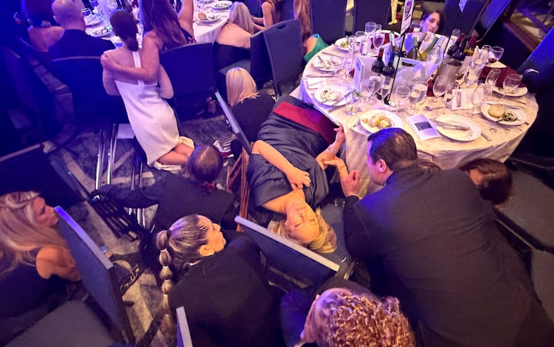 Guests take cover after U.S. President Donald Trump and first lady Melania Trump were rushed out of the White House Correspondents' Association dinner by Secret Service agents in Washington, D.C., U.S. April 25, 2026.