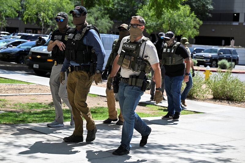 Masked law enforcement officers, including HSI and ICE agents, walk into an immigration court in Phoenix, Arizona, U.S., May 21, 2025.