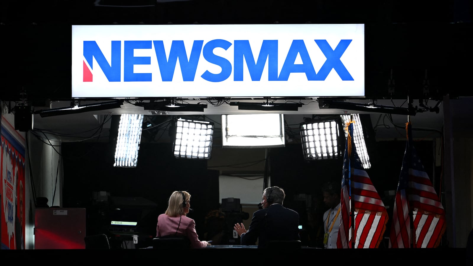 News anchors work at Newsmax's booth during the second day of the 2024 Republican National Convention at the Fiserv Forum in Milwaukee, Wisconsin, July 16, 2024.