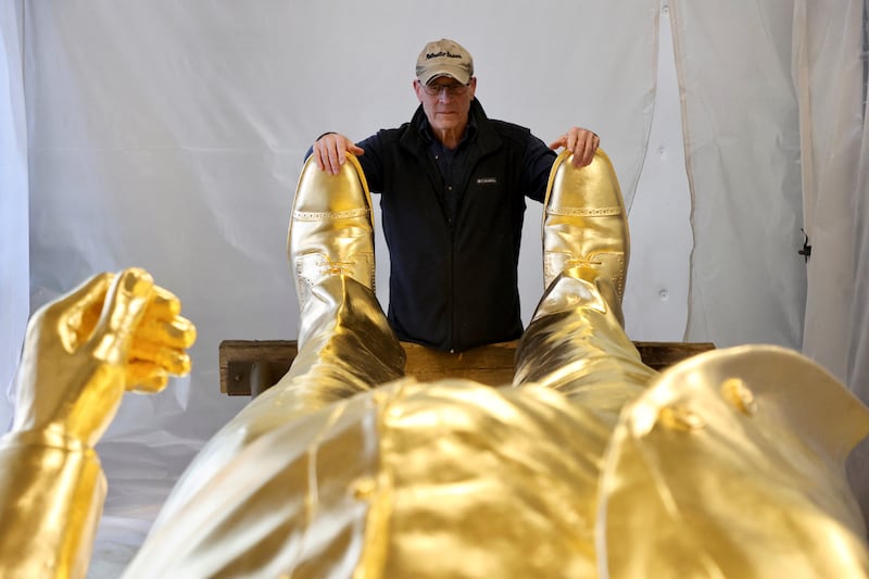 Sculptor Alan Cottrill, 73, examines his gold-leafed bronze statue of Donald Trump at his studio in Zanesville, Ohio.