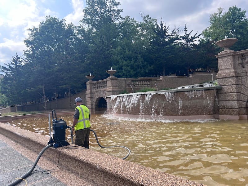 A worker removes sediment from the pool of the fountain on Wednesday.
