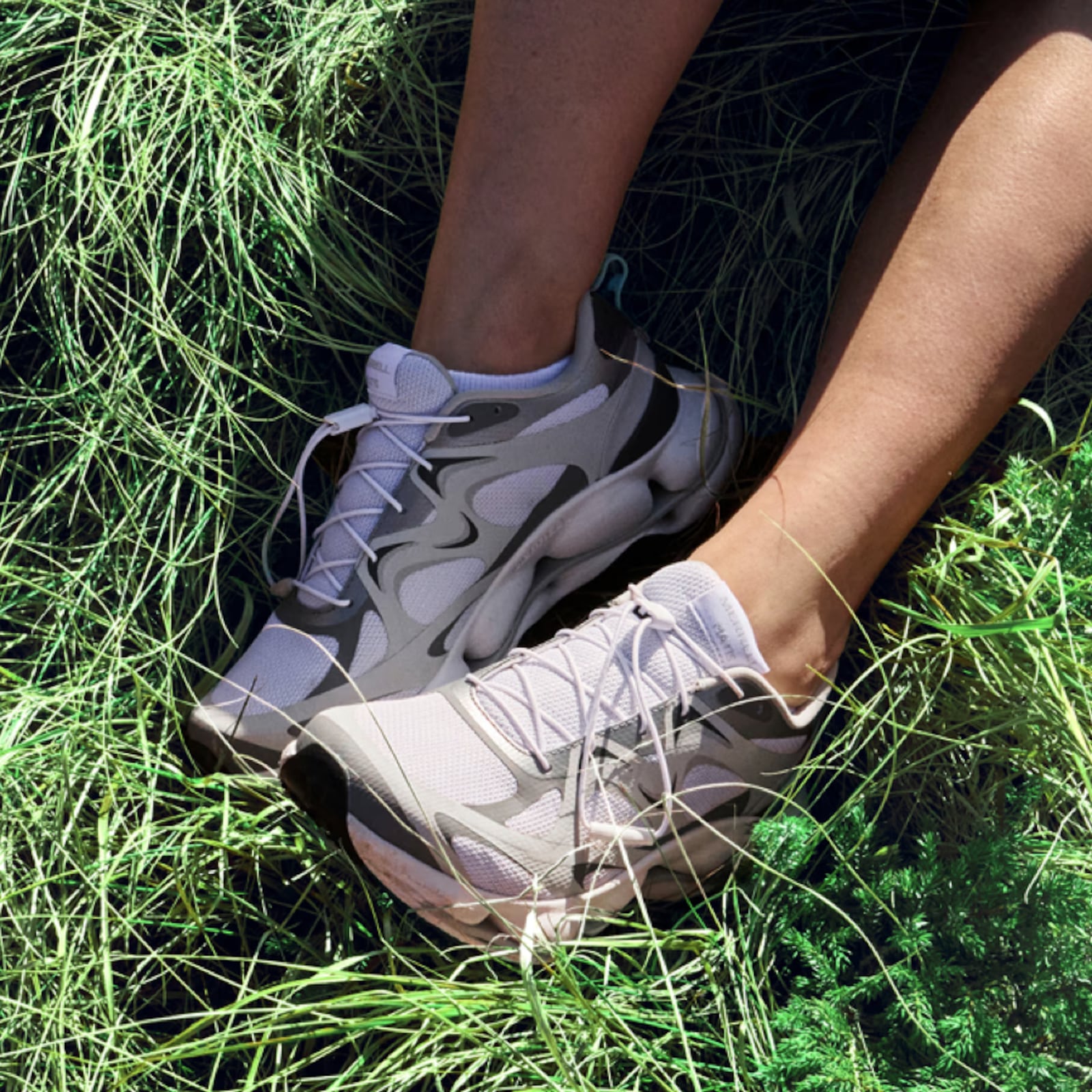 A woman wearing Merrell shoes in a grassy field.