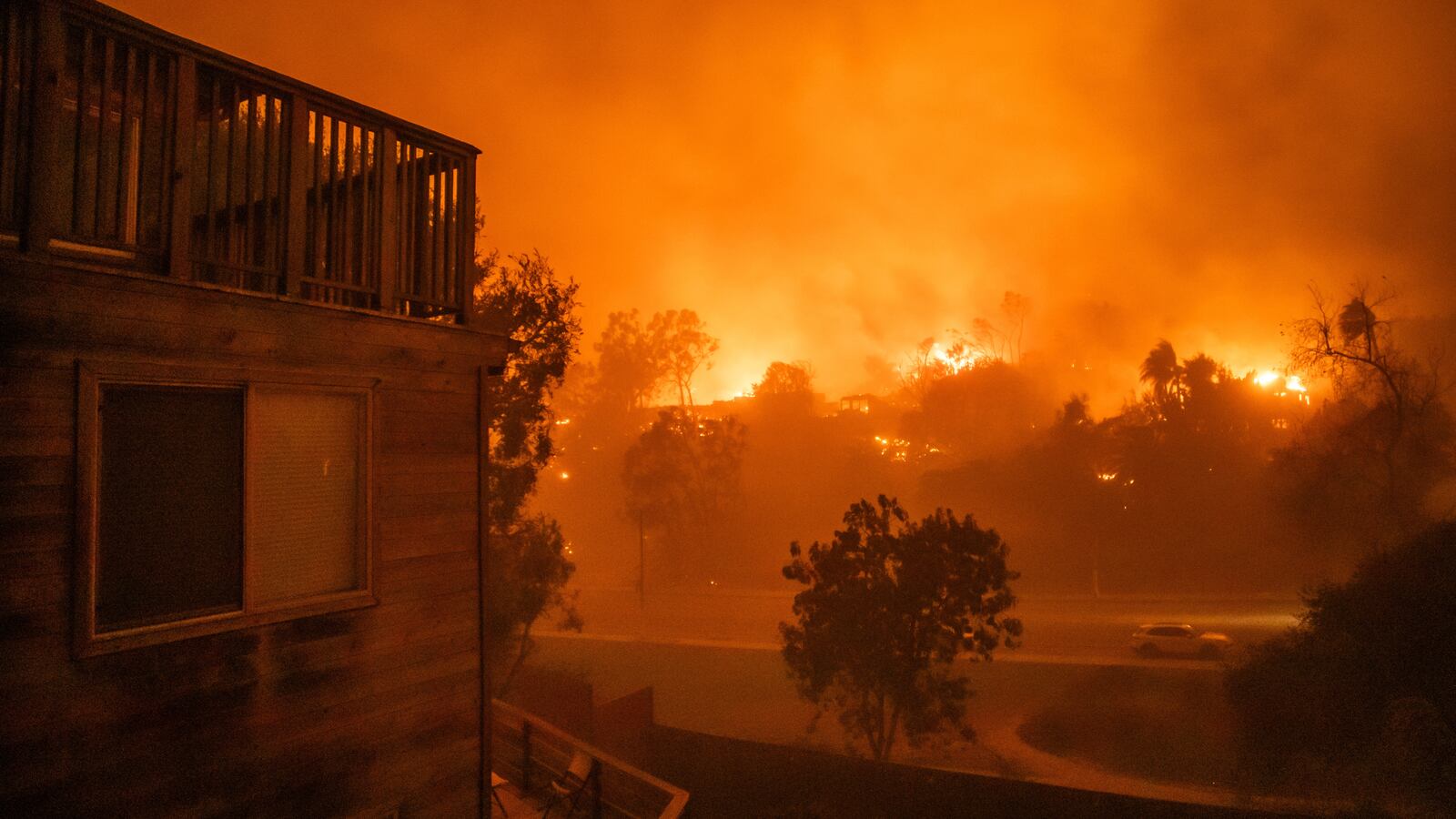 Flames from the Palisades Fire burn homes at Temescal Canyon road during a powerful windstorm on January 8, 2025 in the Pacific Palisades neighborhood of Los Angeles, California. The fast-moving wildfire is threatening homes in the coastal neighborhood amid intense Santa Ana Winds and dry conditions in Southern California.