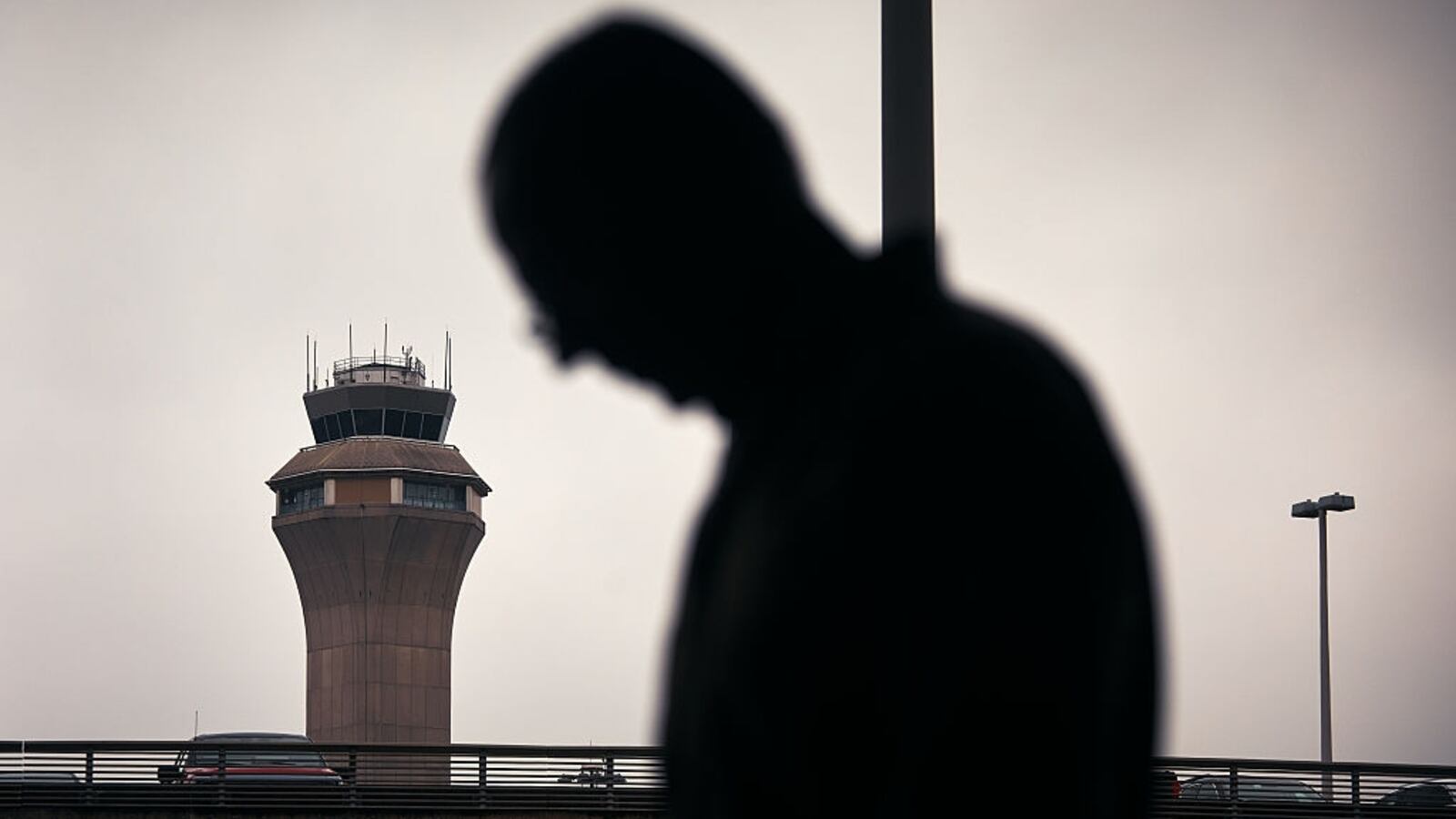 A man stands in front of an airport control tower at Newark, New Jersey.