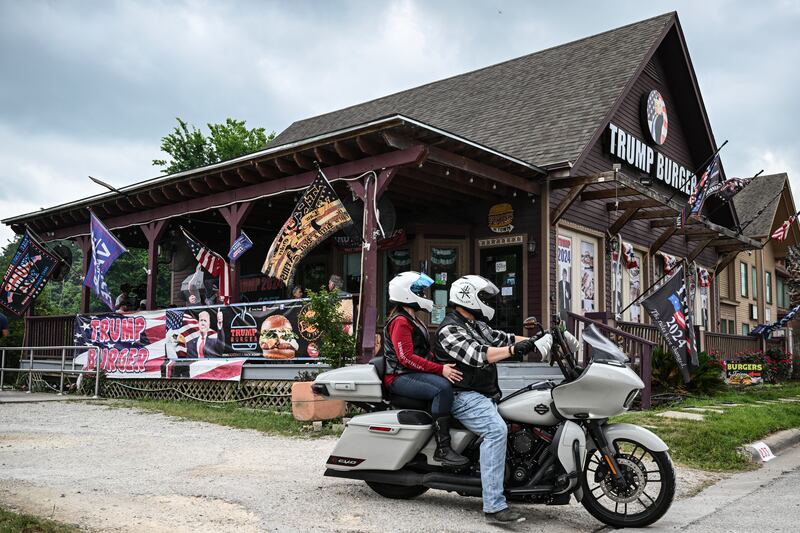Trump Burger.A motorcycle passes in front of the Trump Burger restaurant in Bellville, Texas, on April 19, 2025. It is lunchtime at a Texas eatery called Trump Burger and diners are enjoying fast food and the frenetic first 100 days of their president's second term. Trump is everywhere in this joint with a dozen tables -- in cardboard cutouts of the man eking out his trademark forced smile, on banners from the 2024 campaign, and on hats and T-shirts displayed for sale. It is a franchise of a company with four such Trump-themed outlets in Texas and no equal anywhere else in America. The chain is not linked to the Trump Organization. (Photo by RONALDO SCHEMIDT / AFP) (Photo by RONALDO SCHEMIDT/AFP via Getty Images)