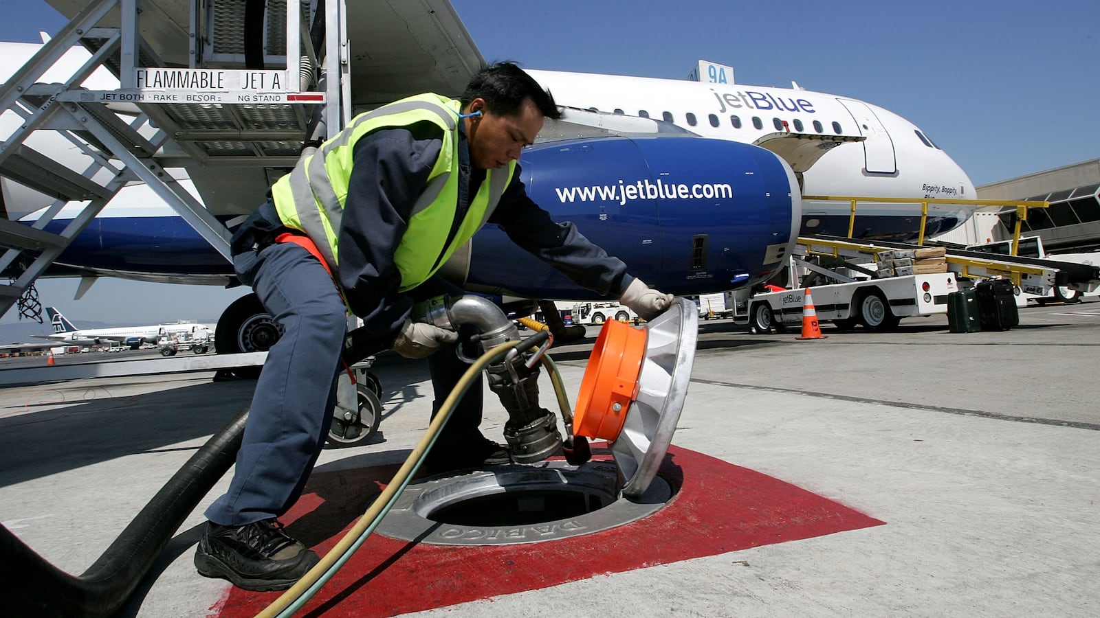 OAKLAND, CA - AUGUST 12: Swissport fueler Benedicto Perez unplugs a fuel line from a ground tank after filling a JetBlue plane at the Oakland International Airport August 12, 2005 in Oakland, California. Northwest Airlines, American Airlines and Jet Blue all hiked fares on select routes on Friday in order to mitigate the impact of recent fuel shortages and the rapidly rising fuel costs as crude oil futures reached over $67 a barrel on Friday. The airline industry has been struggling to contain surging fuel costs, which have overtaken labor costs as the biggest expense for some airlines. (Photo by Justin Sullivan/Getty Images)