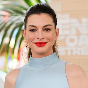 Anne Hathaway wears blue halter top and red lipstick to attend the world premiere of Warner Bros.' "The End Of Oak Street" at Warner Bros. Studios on August 9, 2026, in Burbank, California.
